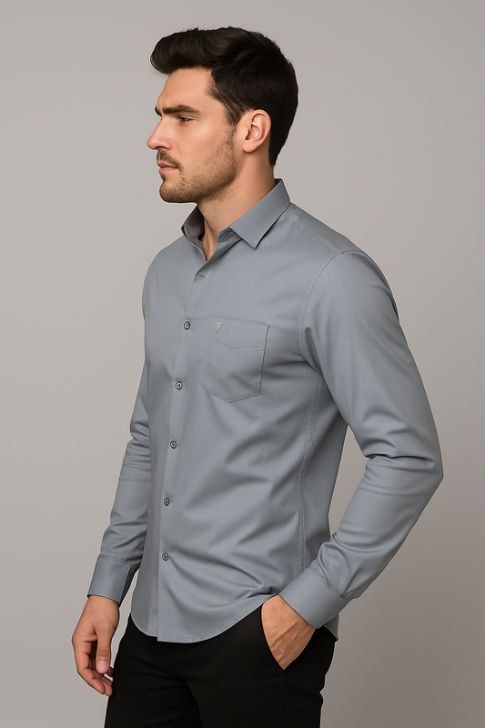 Man wearing a light gray button-up shirt against a gray background
