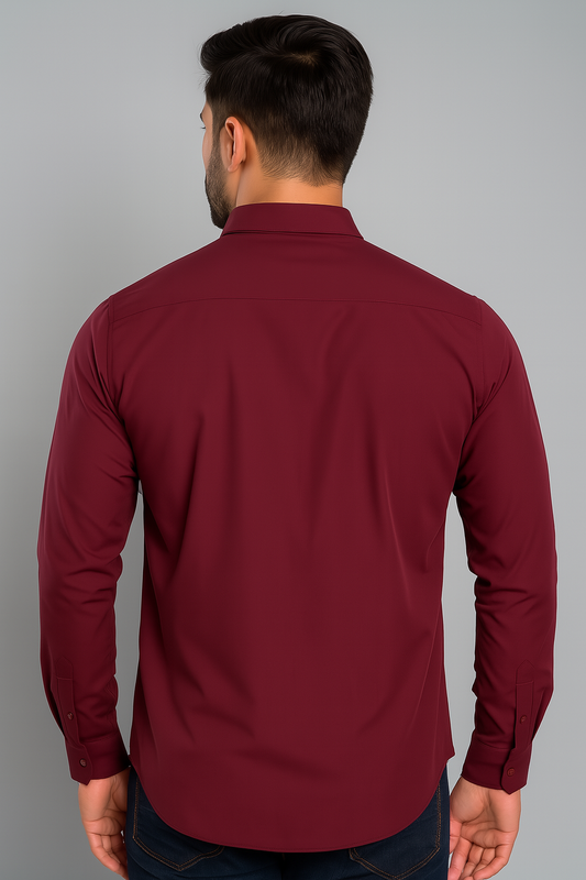 Man wearing a maroon shirt against a gray background