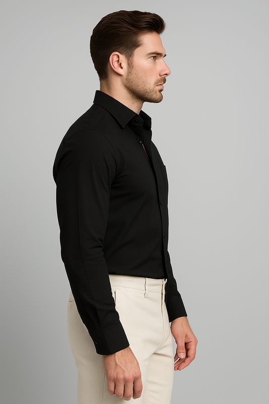 Man wearing a black dress shirt and beige pants against a gray background