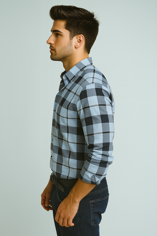 Man wearing a blue and black plaid shirt against a light gray background