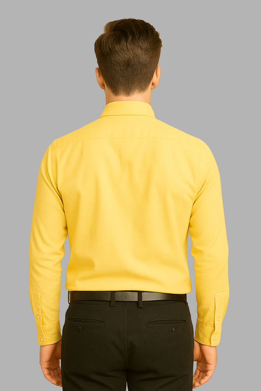 Man wearing a yellow shirt and black pants on a gray background