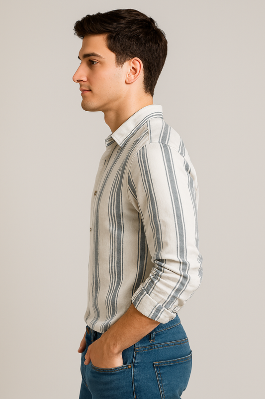 Man wearing a striped shirt and blue jeans against a plain background