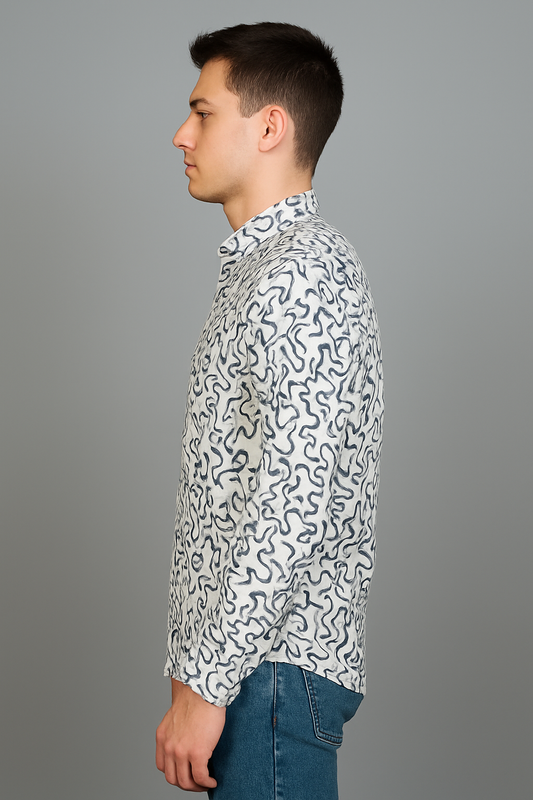 Man wearing a patterned shirt and jeans against a gray background