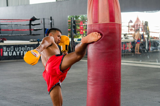 A man standing next to a punching bag