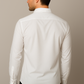 Man wearing a white dress shirt against a beige background