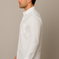 Man wearing a white dress shirt against a beige background