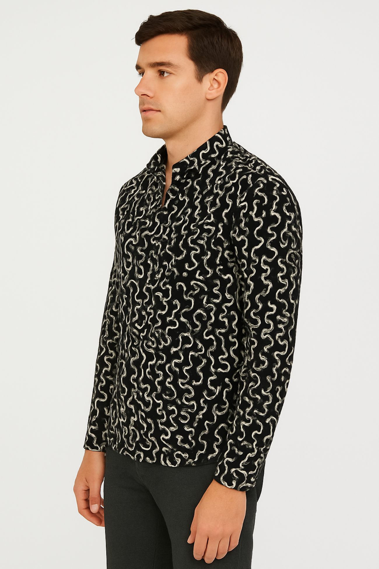 Man wearing a black patterned shirt on a light gray background