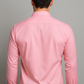 Person wearing a pink shirt against a gray background