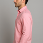 Man wearing a pink shirt against a gray background