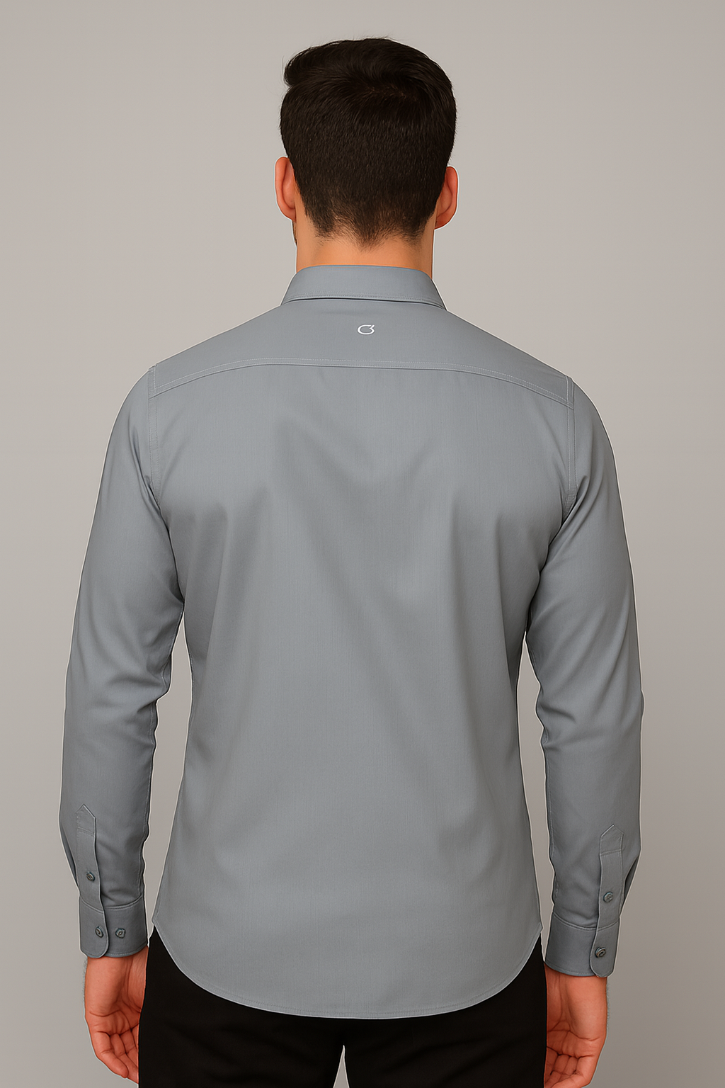 Man wearing a gray dress shirt against a plain background