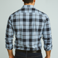 Man wearing a blue and black plaid shirt against a gray background