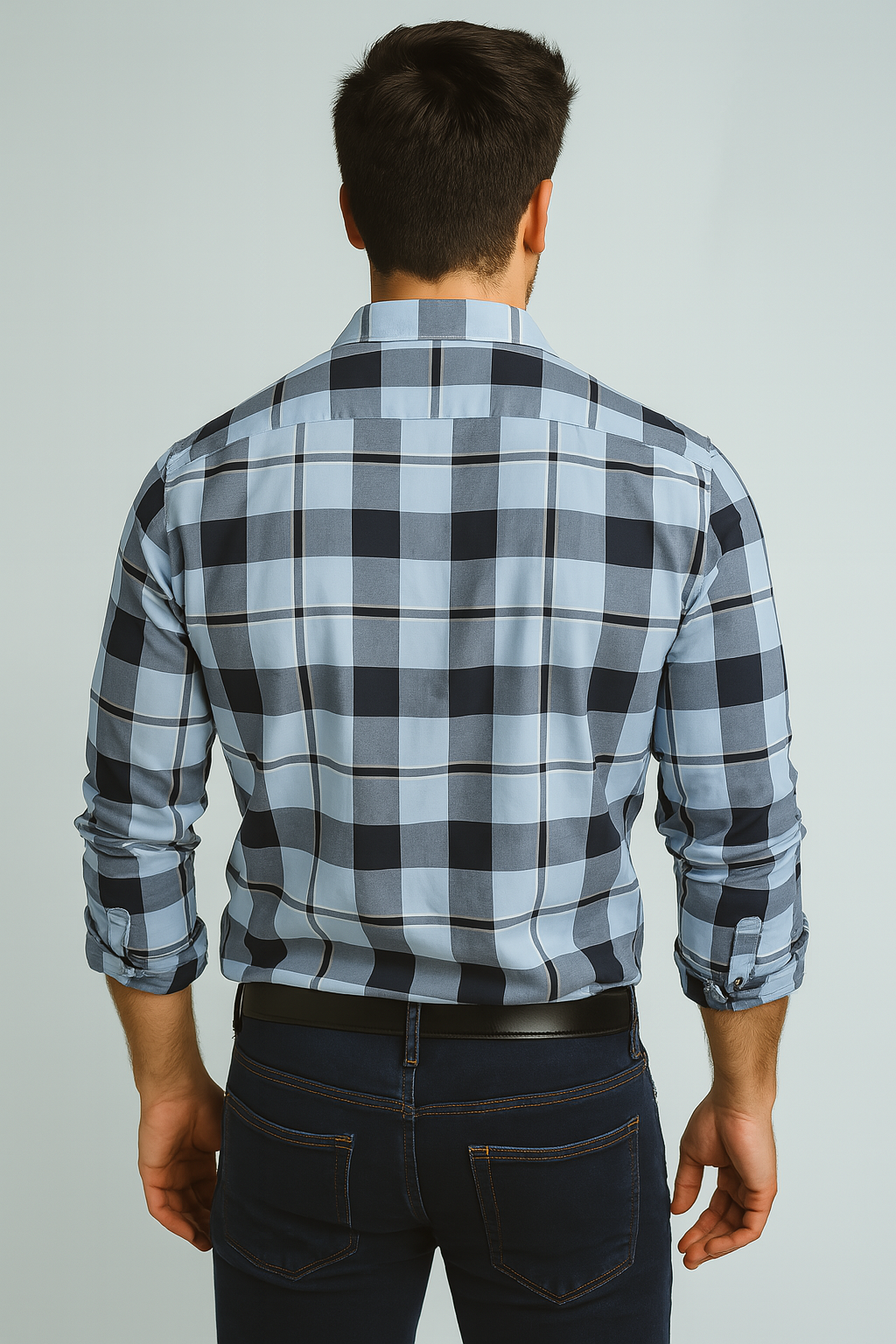 Man wearing a blue and black plaid shirt against a gray background