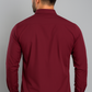 Man wearing a maroon shirt against a gray background