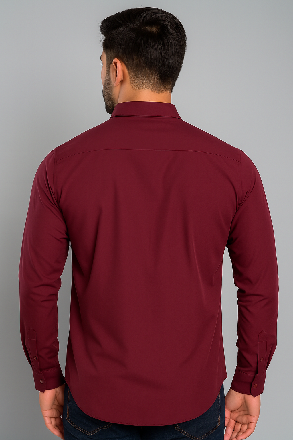 Man wearing a maroon shirt against a gray background
