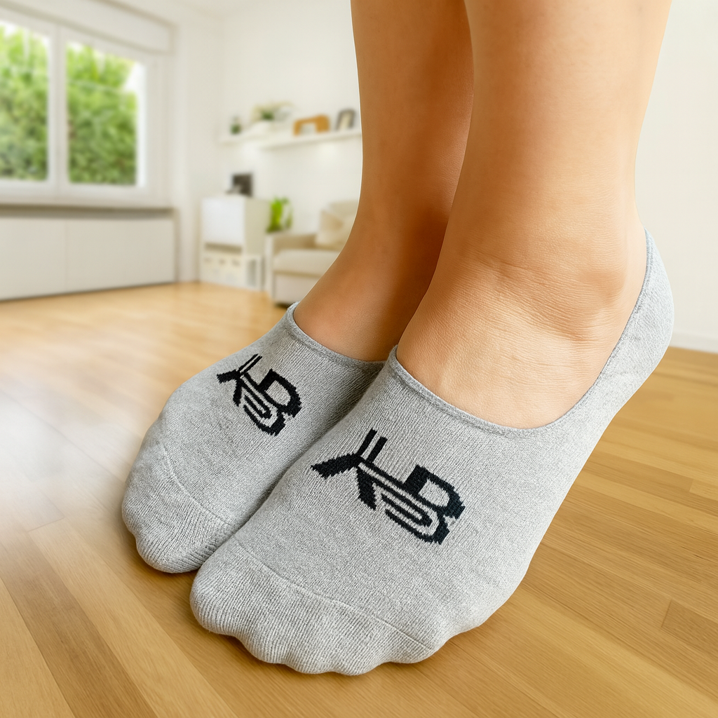 Gray socks with black symbols worn indoors on a wooden floor.