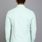 Person wearing a light green shirt against a gray background