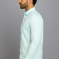 Man wearing a light blue shirt against a gray background