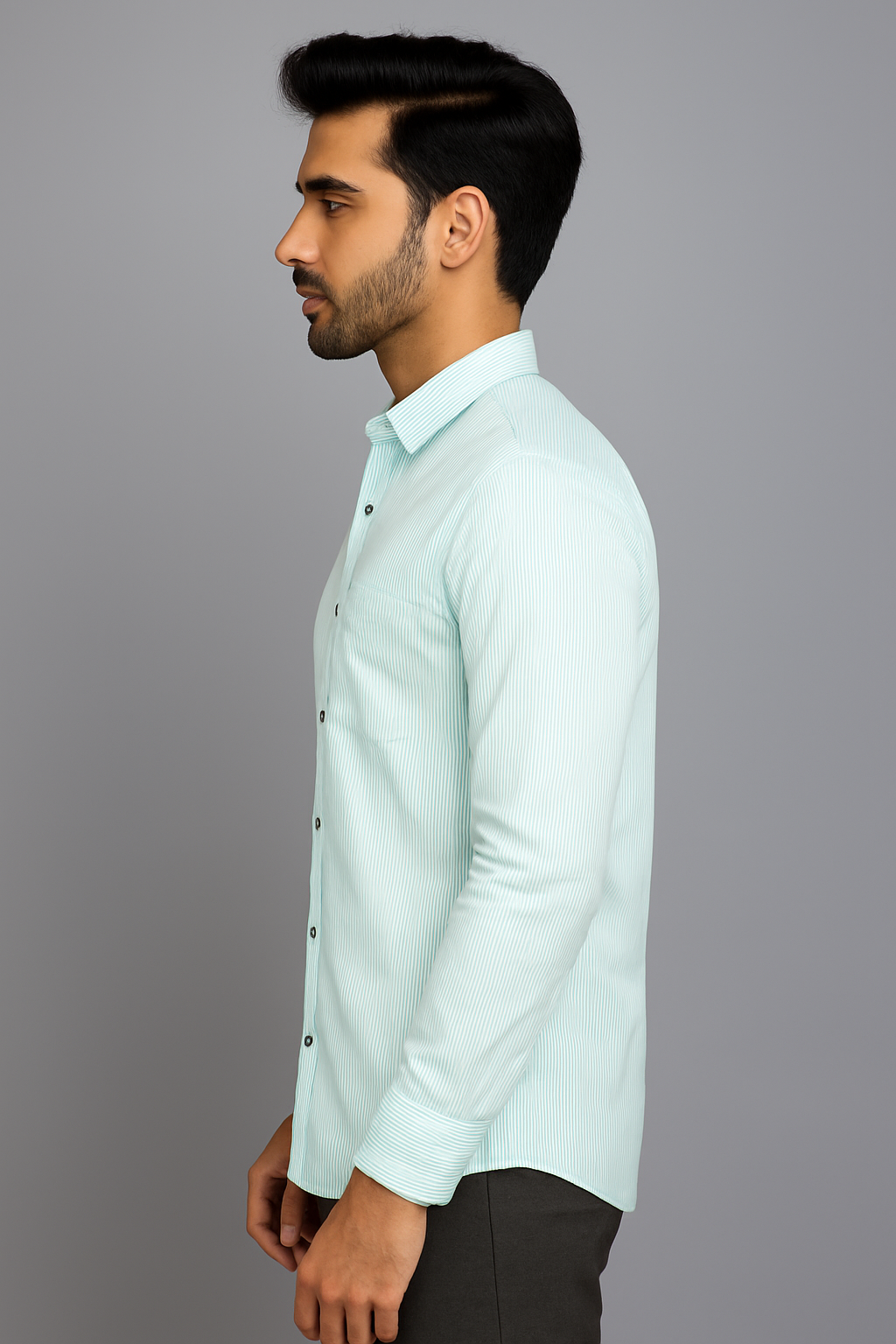 Man wearing a light blue shirt against a gray background