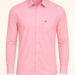 Pink shirt with a small logo on a beige background