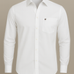 White dress shirt with a small logo on a beige background