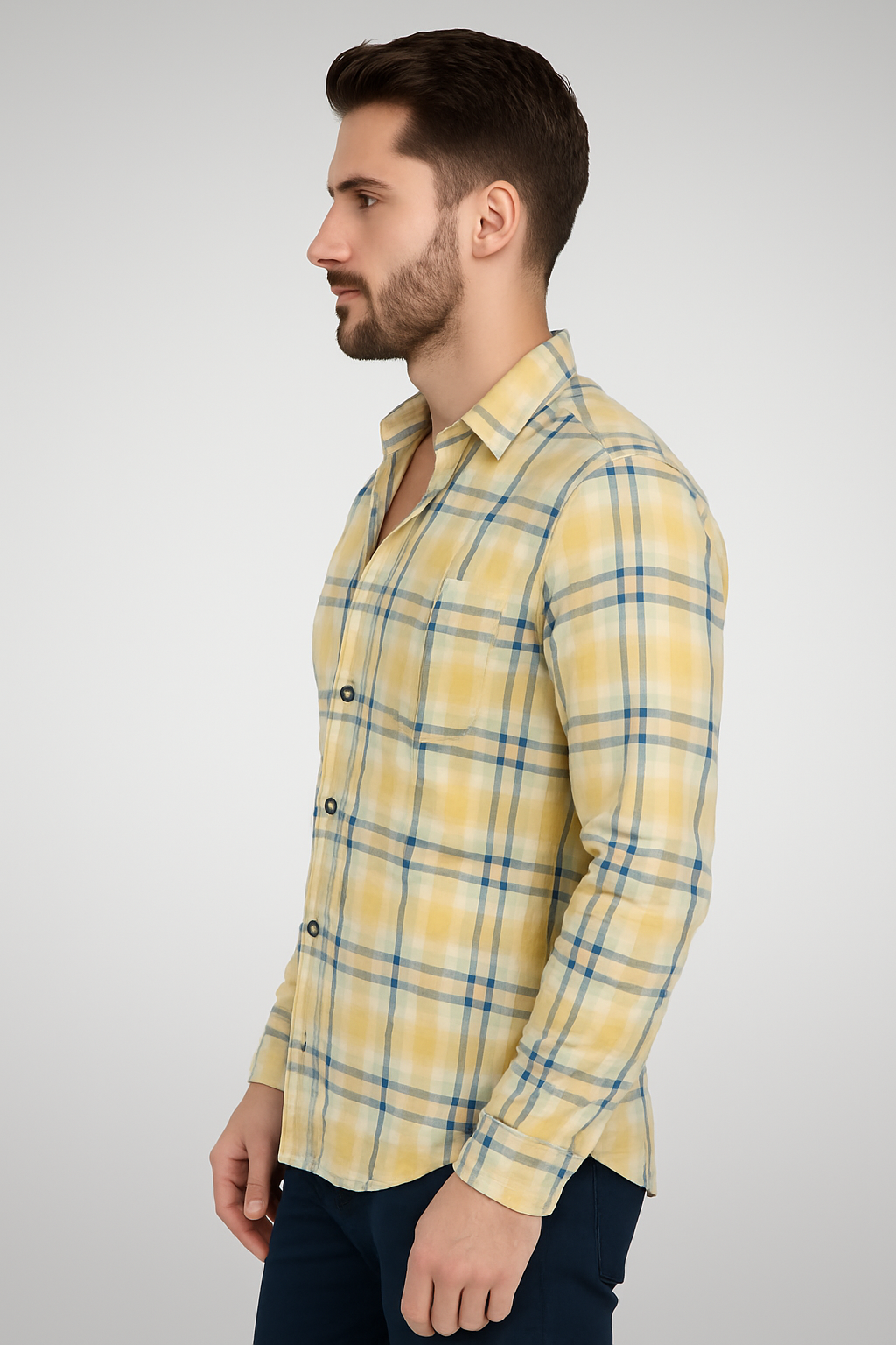 Man wearing a yellow plaid shirt against a gray background