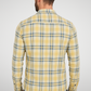 Man wearing a yellow plaid shirt on a plain background