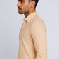 Man wearing a beige long-sleeve shirt against a light gray background