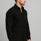 Man wearing a black shirt against a gray background