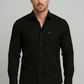 Man wearing a black button-up shirt against a gray background