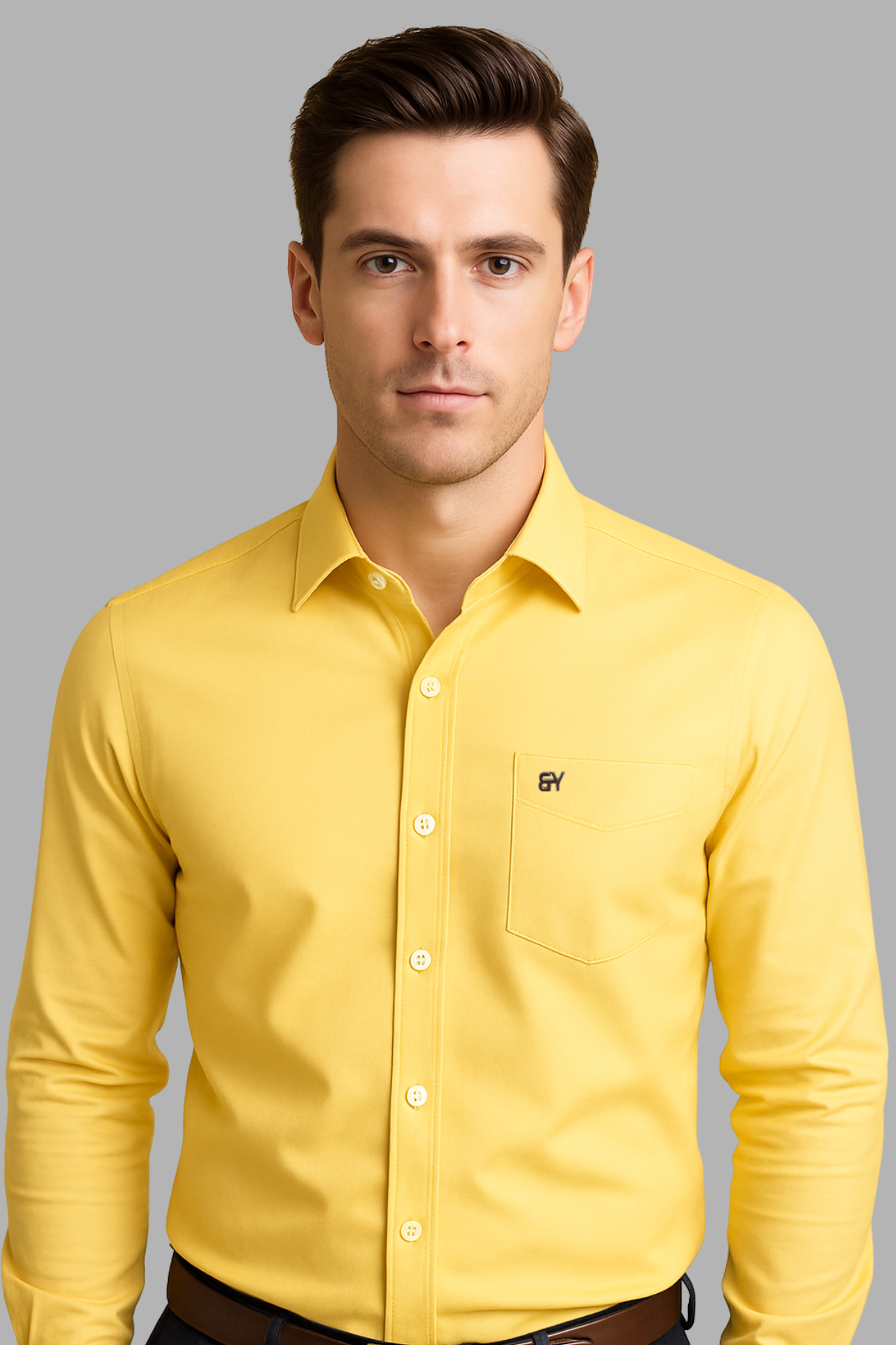 Man wearing a yellow shirt with a logo on a gray background