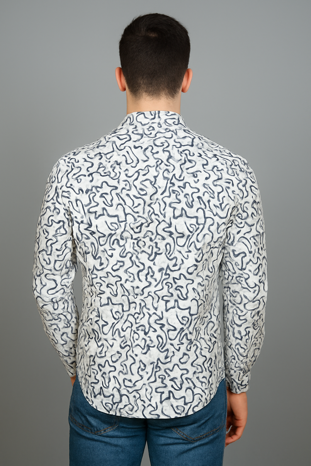Person wearing a white shirt with black abstract pattern on a gray background