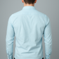 Man wearing a light blue dress shirt against a gray background