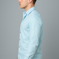 Man wearing a light blue shirt against a gray background