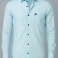 Light blue shirt with black buttons on a gray background
